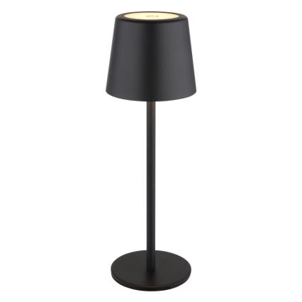 Stojacia lampa svieti. Má čierny kovový stĺpik a tienidlo, ktoré je na vrchu svetlé. Stojí na kruhovom podstavci.