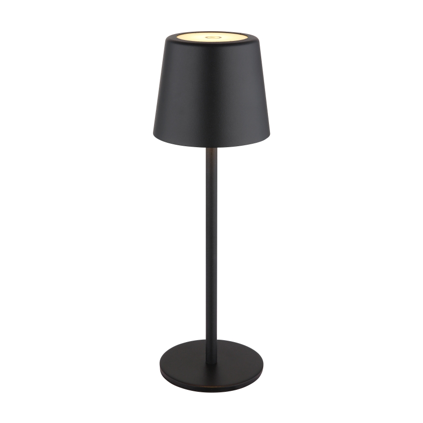 Stojacia lampa svieti. Má čierny kovový stĺpik a tienidlo, ktoré je na vrchu svetlé. Stojí na kruhovom podstavci.
