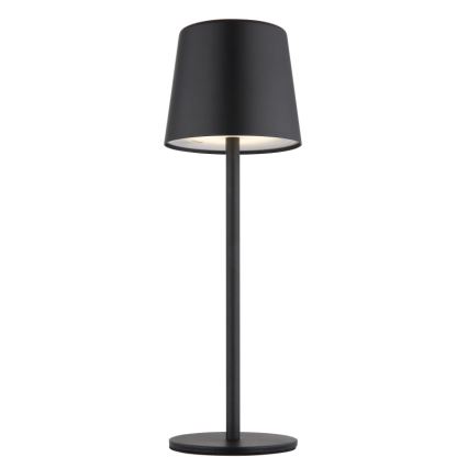 Stojacia lampa svieti. Má čierny valcový tienidlo na dlhej, tenkej, čiernej nohe s okrúhlou základňou. Lampa je umiestnená na bielom pozadí.