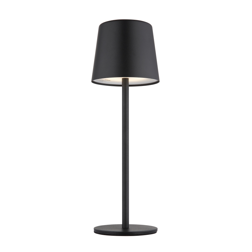 Stojacia lampa svieti. Má čierny valcový tienidlo na dlhej, tenkej, čiernej nohe s okrúhlou základňou. Lampa je umiestnená na bielom pozadí.