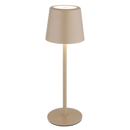 Stolná lampa s pieskovou farbou svieti. Má valcový tienidlo a vysokú, štíhlu nohu s okrúhlou základňou. Lampa je umiestnená na bielom pozadí.