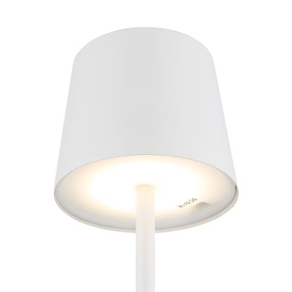 Biela stolová lampa s valcovým tienidlom svieti. Tienidlo je hore otvorené a spodná časť tienidla má vyrytý text DC 5V/4A. Lampa stojí na bielom podklade.