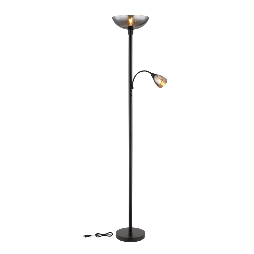 Stojacia lampa s dvoma tienidlami svieti. Hlavné tienidlo je miskovité, tmavosivé, menšie je kužeľovité, zlaté. Lampa je vysoká, čierna, na kruhovom podstavci, s viditeľným káblom.