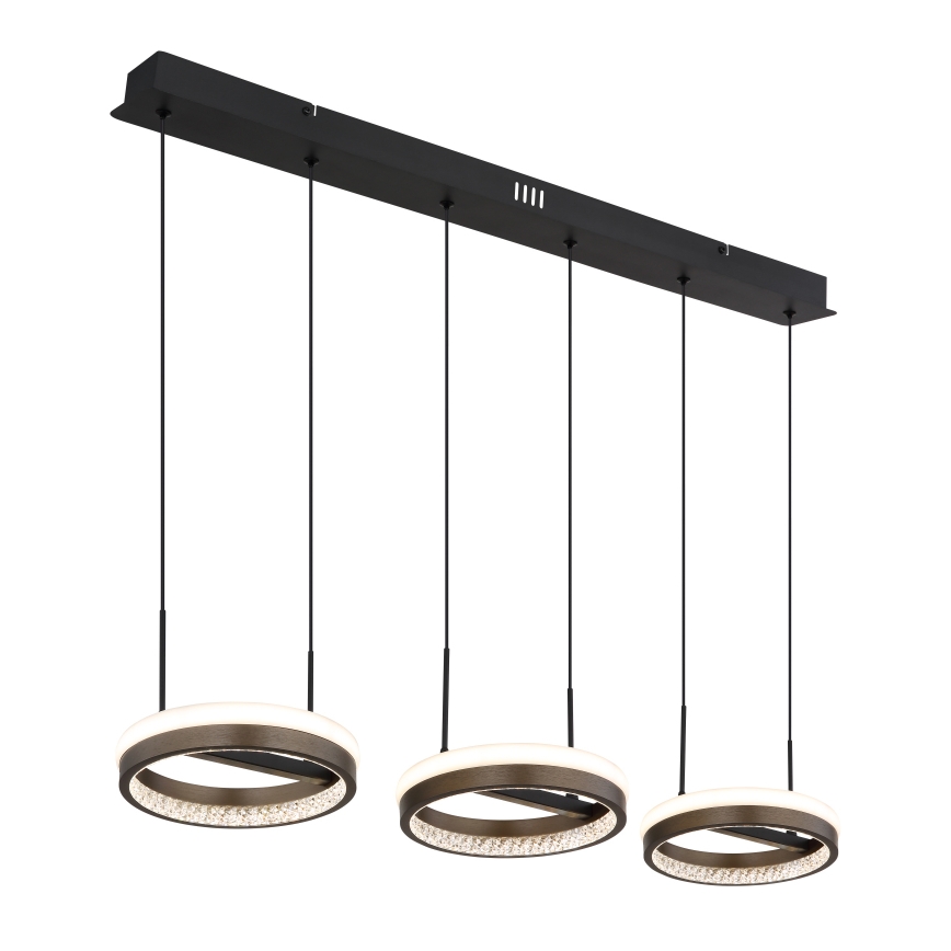 Trojramenné závesné svietidlo s kruhovými tienidlami, osvetľuje priestor. Každé tienidlo má vnútorný svetelný prstenec a ozdobný kryštálový lem. Svietidlo je upevnené na čiernej koľajnici.