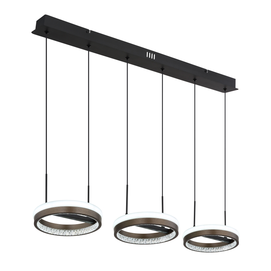 Trojramenné závesné svietidlo s kruhovými tienidlami z hnedého kovu a kryštálmi visí z čiernej stropnej lišty. Tienidlá sú osvetlené LED diódami.