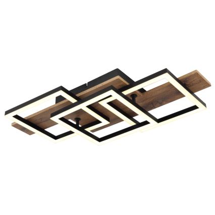 Svietidlo svieti na strop. Jeho dizajn pozostáva z prepletených čiernych štvorcových rámov s LED osvetlením a drevenými prvkami. Celok je pripevnený na strop.