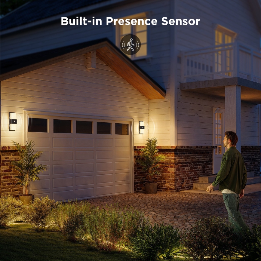 Muž kráča popri dome s vonkajšími svietidlami s zabudovaným senzorom pohybu. Svietidlá osvetľujú chodník a záhradu. Text na obrázku: „Built-in Presence Sensor“.