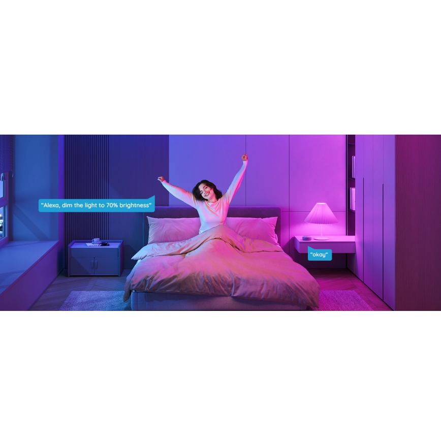 Žena v posteli dvíha ruky. Svetlo v spálni je tlmené na 70% jasu hlasovým ovládaním: „Alexa, zníž svetlo na 70% jasu.“ Systém odpovedá: „Okay“.