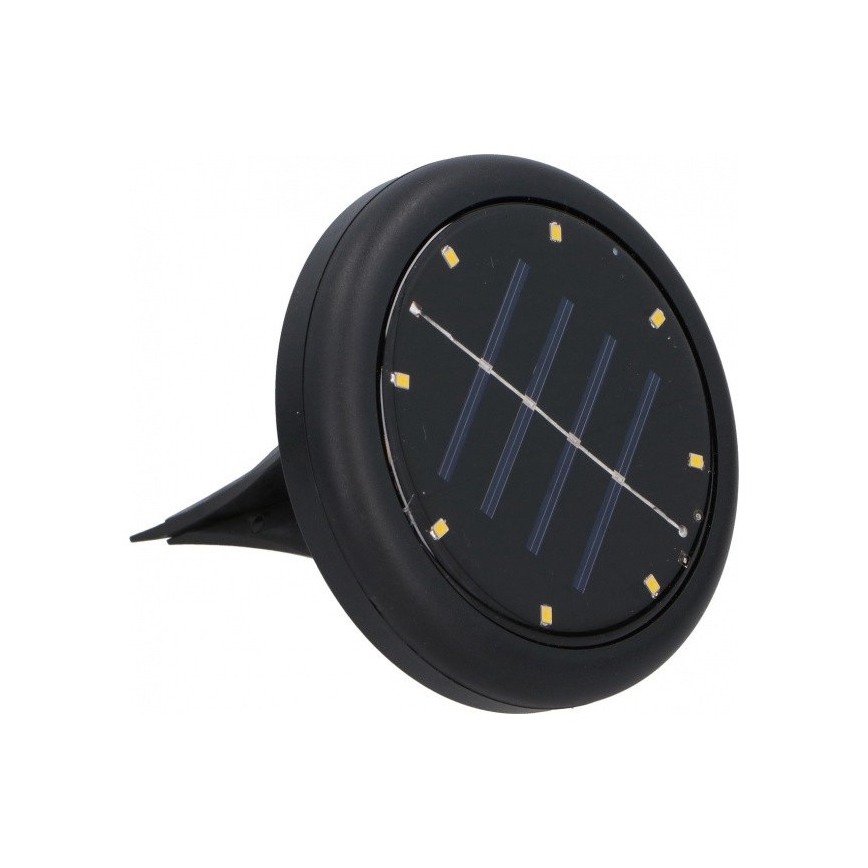 Solárny svietič s LED diódami je umiestnený na špicatom kolíku. Slnečný panel nabíja batériu na osvetlenie. Svietič je čierny a okrúhly.