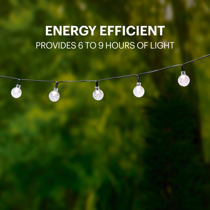 Solárne svetielka s guľatými tienidlami visia na čiernom kábli pred rozmazaným zeleným pozadím. Text: ENERGY EFFICIENT PROVIDES 6 TO 9 HOURS OF LIGHT.