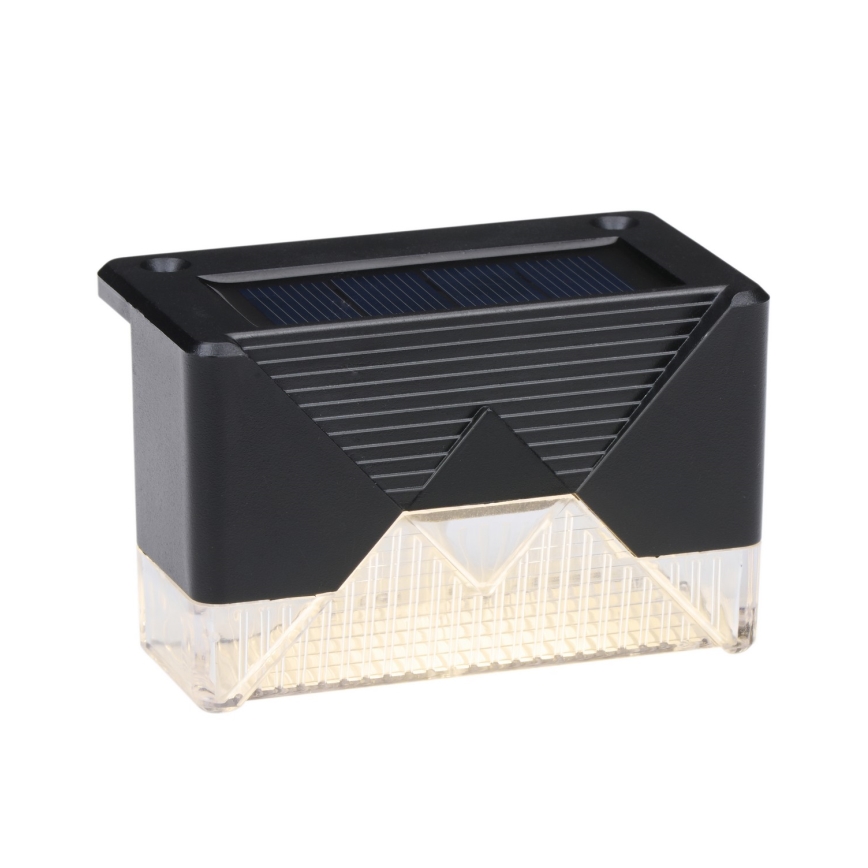 Solárny svietiaci blok svieti. Je čierny s priehľadnou spodkom, kde sú viditeľné diódy. Horná časť obsahuje solárny panel.