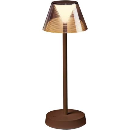 Stolná lampa s hnedým kovový stojanom a hnedým tienidlom z priehľadného materiálu s vnútorným svetelným zdrojom, svieti na bielom podklade. Lampa stojí na kruhovej základni.