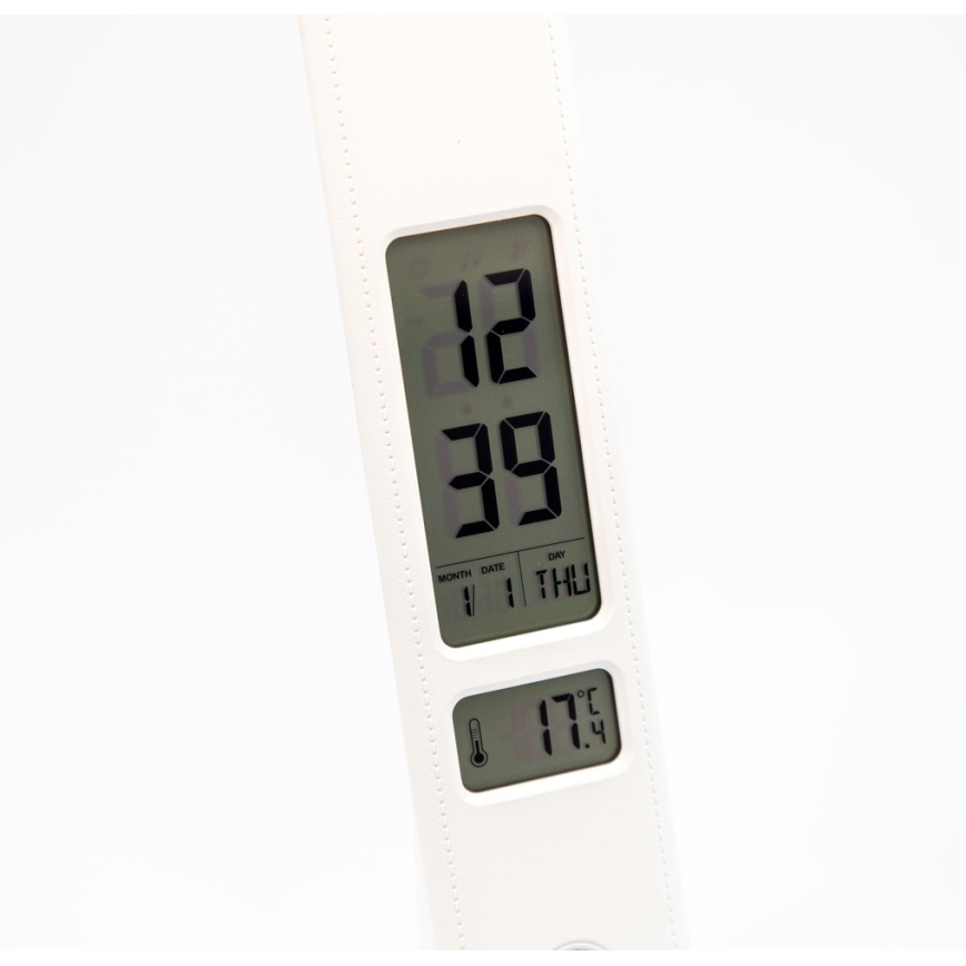 Biela digitálna budíková lampa zobrazuje čas 12:39, dátum 1.1. a deň štvrtok. Teplota je 17.4 °C.