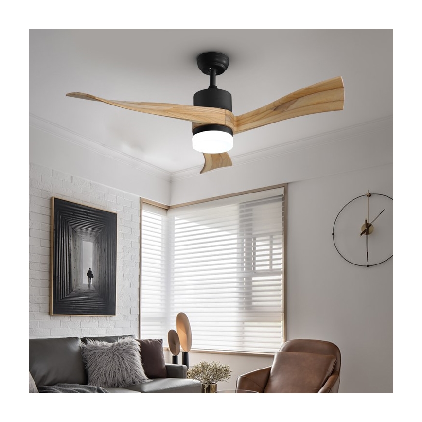 Drevený stropný ventilátor s integrovaným osvetlením rotuje v obývacej izbe s bielymi stenami, oknom so žalúziami a hnedou sedačkou.