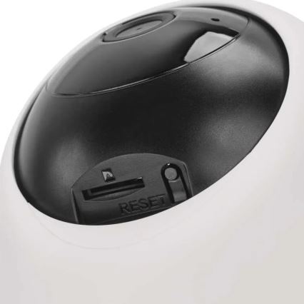 Bezdrôtová kamera s čiernou šošovkou a bielym telom je zobrazená z boku. Na spodnej časti je viditeľný slot pre pamäťovú kartu a tlačidlo RESET. Kamera je na bielom pozadí.