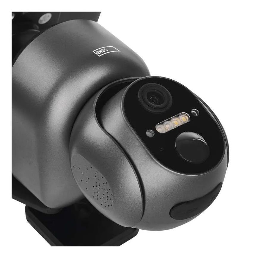 Šedá bezpečnostná kamera s objektívom a LED diódami sníma obraz. Na vrchnej časti je nápis „EMOS“. Kamera je umiestnená na neviditeľnej montážnej konštrukcii.