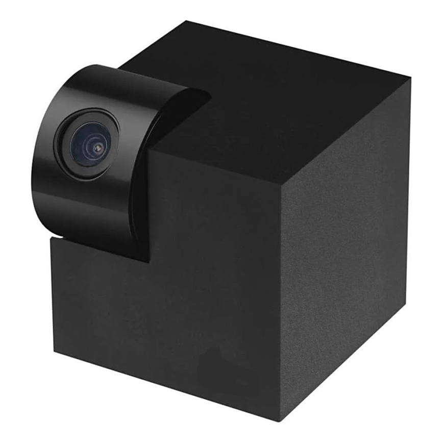 Kamera zaznamenáva obraz. Je pripevnená k čiernej kockovitej základni. Celok je na bielom pozadí.