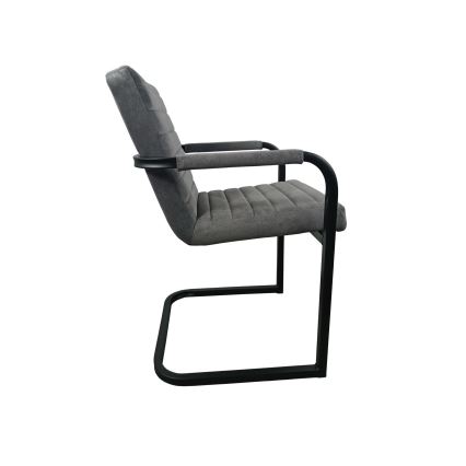 Šedá čalúnená stolička s podrúčkami a čiernym kovovýn podnožím v tvare podkovy stojí na bielom pozadí.