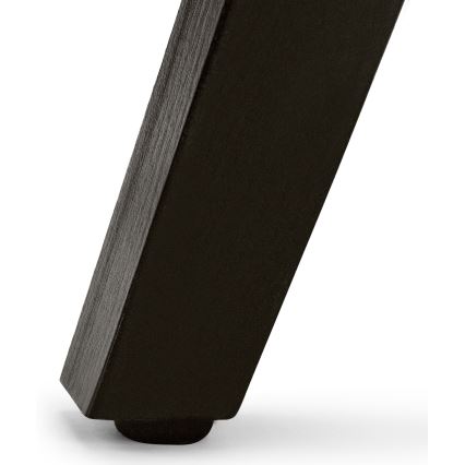 Čierna stolová noha stojí na svetlom podklade. Noha je zakončená tmavou ochrannou podložkou. Je mierne šikmá.