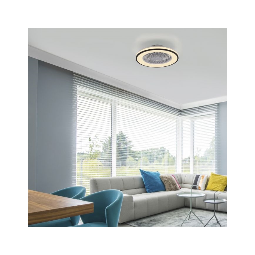 Stropný ventilátor s osvetlením je pripevnený k stropu. Ventilátor je zapustený, v obývacej izbe s rohovou sedačkou, dreveným stolom a oknami s žalúziami.
