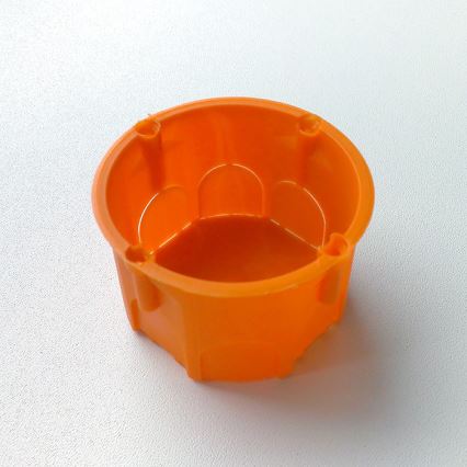 Pomarančová plastová nádoba s výstupkami je umiestnená na bielom povrchu.