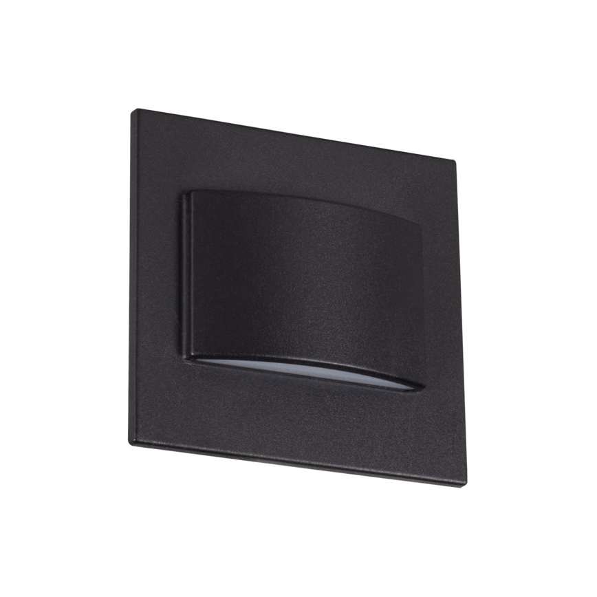 Nástené svietidlo svieti. Je štvorcového tvaru, tmavosivej farby, s mierne prehnutým vnútorným prvkom, ktorý rozptyľuje svetlo. Svietidlo je umiestnené na bielom pozadí.