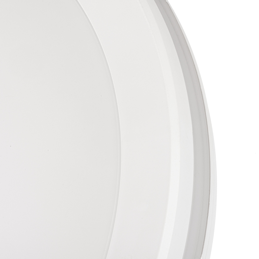 Biela zapustená lampa je zobrazená zblízka na bielom pozadí. Lampa má okrúhly tvar s viditeľným vnútorným difúzorom.