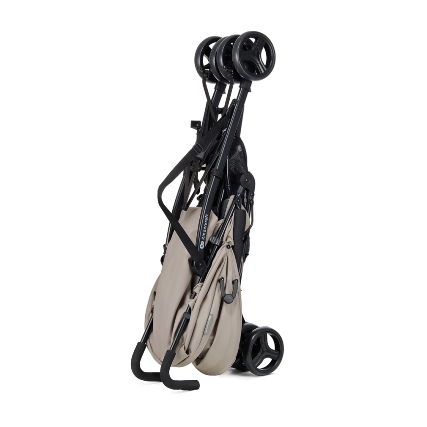 Detský kočík je zložený, stojí na dvoch zadných kolieskach. Je béžovej farby s čiernymi kovovými časťami. Zložený kočík je kompaktný a stabilný.