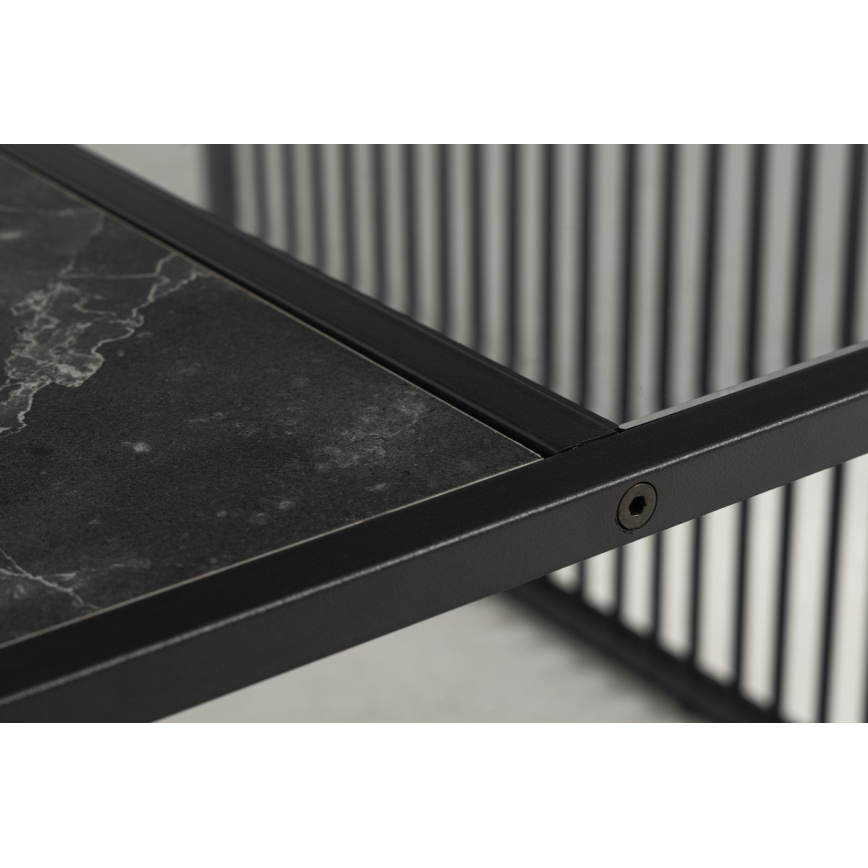 Stolík s tmavosivou mramorovou doskou a čiernym kovový rámom s vertikálnymi priečkami. Doska je vsadená do rámu. Viditeľný je jeden skrutkový spoj.