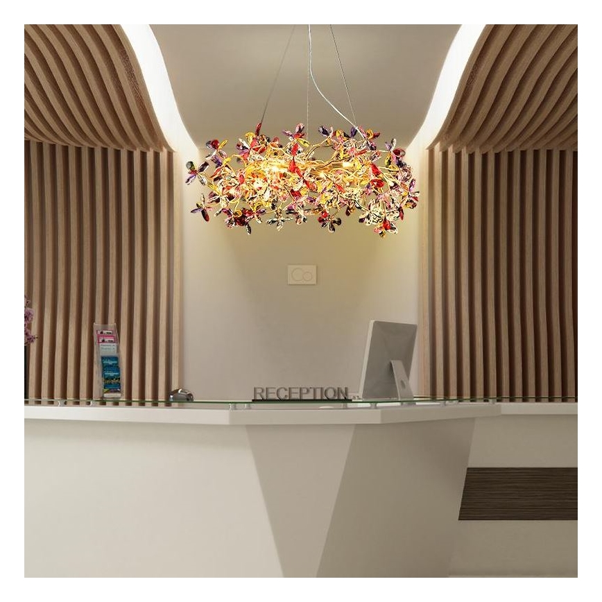 Lampa s tvarom kvetov visí nad recepciou. Recepcia je biela s nápisom „RECEPTION“. Po stranách recepcie sú drevené steny.