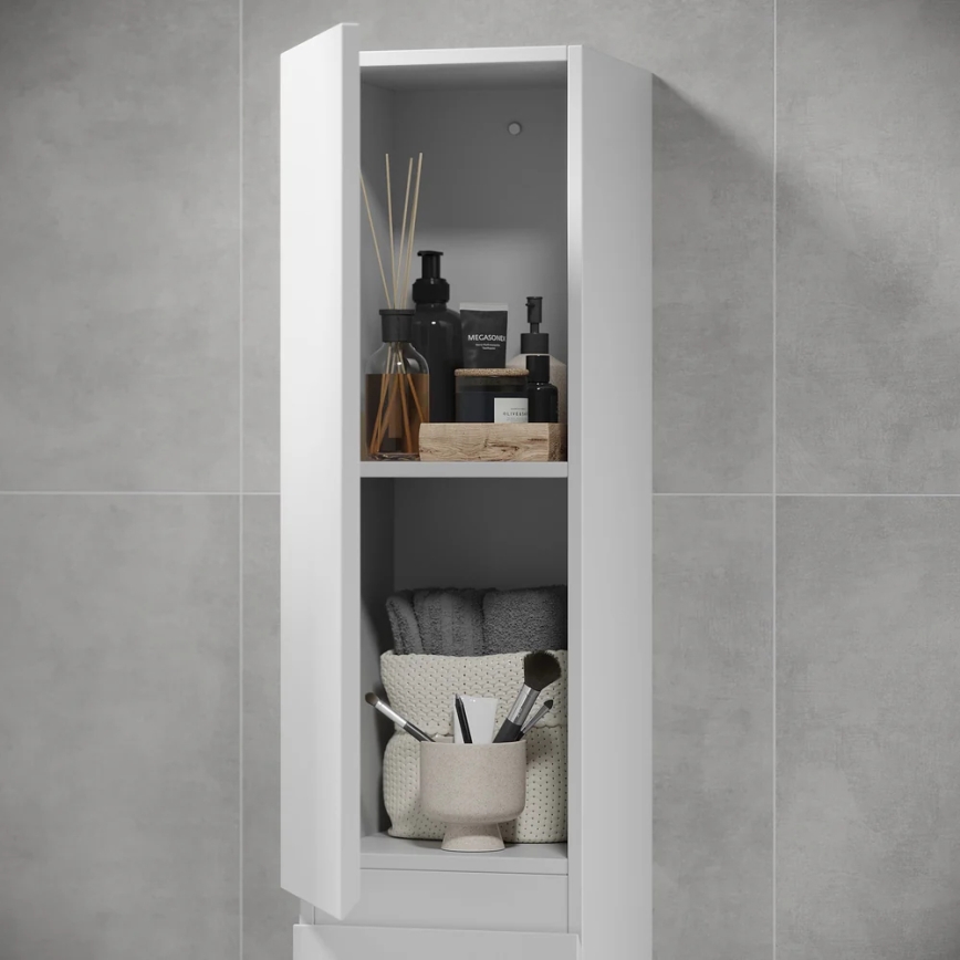 Biela kúpeľňová skrinka s otvorenými dvierkami odhaľuje police s kozmetikou, uterákmi a doplnkami. Na policiach sú fľaše, sviečky, aromatické tyčinky a kozmetické štetce v nádobke. Skrinka je umiestnená v kúpeľni s šedými obkladačkami.