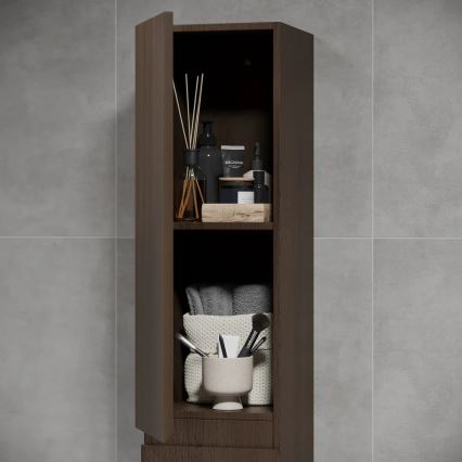 Tmavohnedá kúpeľňová skrinka s otvorenými dvierkami ukazuje tri police s kozmetikou, uterákmi a kozmetickými potrebami. Skrinka stojí pri sivej obkladacej stene.