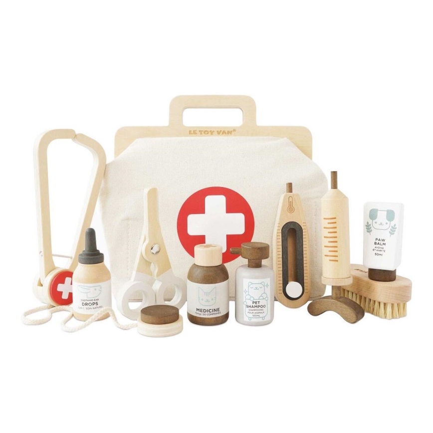 Drevená lekárnička s nástrojmi pre zvieratá: stetoskop, nožnice, fľaštičky s nápismi „Soothing Ear Drops“, „Medicine 20 comprimés“, „Pet Shampoo 100ml“, „Paw Balm 50ml“, teplomer, injekcia, kefka.