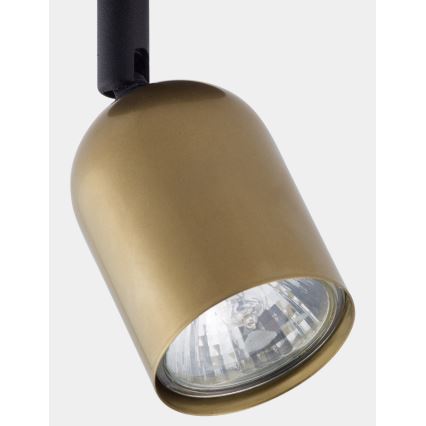 Zlatá kovová bodová lampa s čiernym ramenom visí v priestore. Lampa je otočená smerom dole a vyžaruje svetlo.