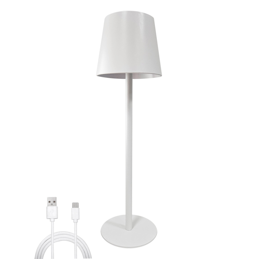 Biela stojacia lampa s valcovým tienidlom stojí na kruhovom podstavci. K lampe je pripojený nabíjací USB kábel s konektormi USB-A a USB-C. Lampa je zobrazená na bielom pozadí.