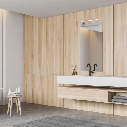 Drevená kúpeľňová skrinka s umývadlom a zrkadlom je umiestnená v kúpeľni s drevenými stenami. Na stolíku vedľa je uterák a kozmetika.