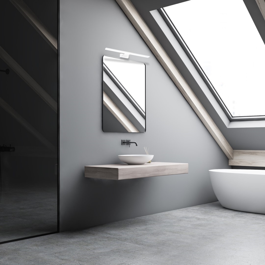 Umývadlo sa nachádza na drevenom pulte pod zrkadlom v šikmej sivej miestnosti s oknom na streche a sprchovacím kútom.