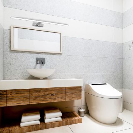 Drevená umývadlová skrinka s dvoma zásuvkami je umiestnená v kúpeľni. V kúpeľni je aj voľne stojaca vaňa, okrúhle zrkadlo a steny sú obložené bielymi obkladmi.