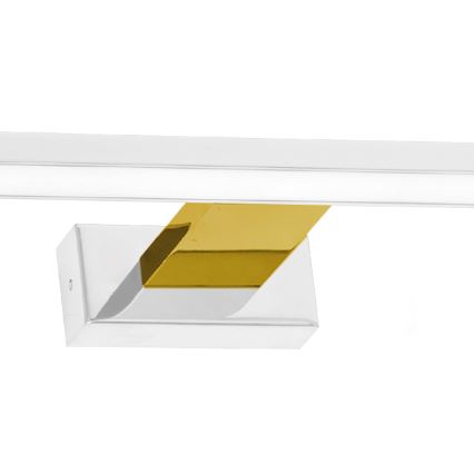 Dlhá biela LED lampa je pripevnená na stenu. Rozmery sú: dĺžka 600 mm, výška 115 mm a šírka 40 mm. Základňa lampy je zlatá.