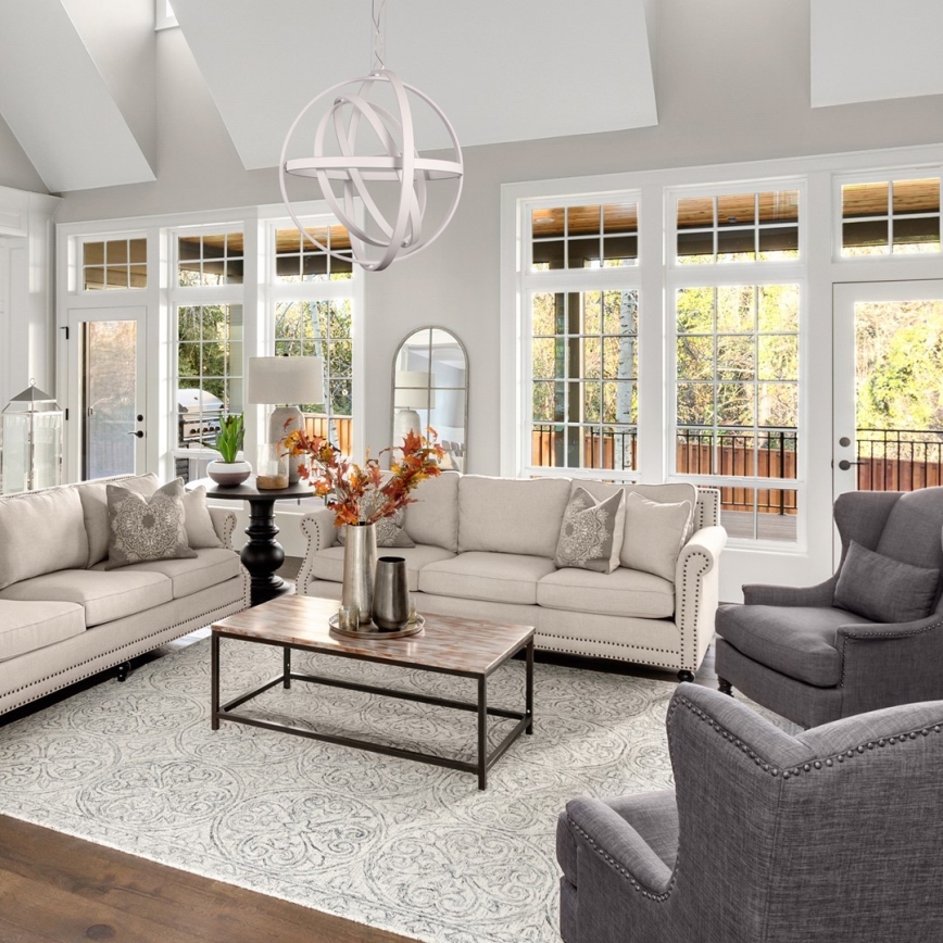 Svetlozelená pohovka s vankúšmi sa nachádza v tmavosivej miestnosti. Nad pohovkou visí moderné biele závesné svietidlo v tvare gule. Miestnosť má veľké okná a svetlý drevený podlaha.