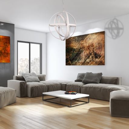 Biela guľová lampa visí zo stropu. Je tvorená prepletenými kruhovými prvkami. Svetlo je zavesené na tenkom kábli.