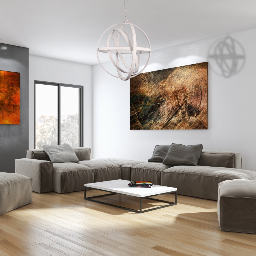 Biela guľová lampa visí zo stropu. Je tvorená prepletenými kruhovými prvkami. Svetlo je zavesené na tenkom kábli.