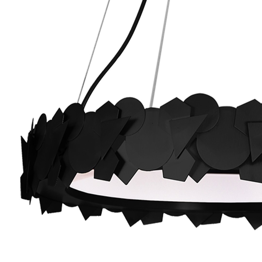 Zlatý kruhový luster visí zo stropu. Je zdobený geometrickými zlatými prvkami. Luster je osvetlený z vnútra.