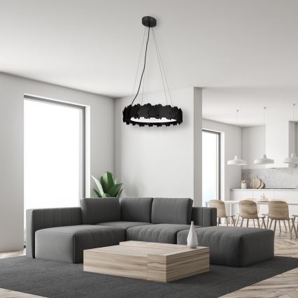 Svetlozelená sedačka s prehozom sa nachádza v obývacej izbe s výhľadom na bazén a hory. Nad sedačkou visí kruhový luster zložený z mnohých menších prvkov.