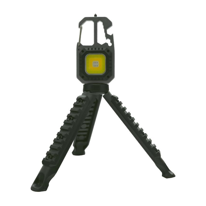 Prenositelná LED lampa s trojnožkou svieti. Lampa je tmavosivá, má karabínu a integrovaný otvárač. Stojan je z plastického materiálu s drážkami.