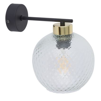 Nástenná lampa s guľovým tienidlom zo svetlozeleného, štruktúrovaného skla, čiernou kovovou konštrukciou a zlatým prstencom, je pripevnená na stenu. Lampa je osvetlená žiarovkou.