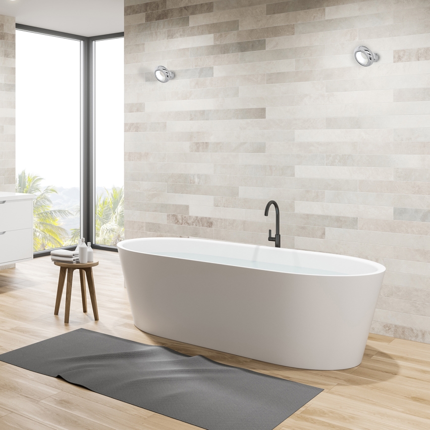 Biela voľne stojaca vaňa s vodou sa nachádza v kúpeľni s dlaždicovou stenou a drevenou podlahou. Pred vaňou je tmavá rohož. V blízkosti je malý drevený stolík.