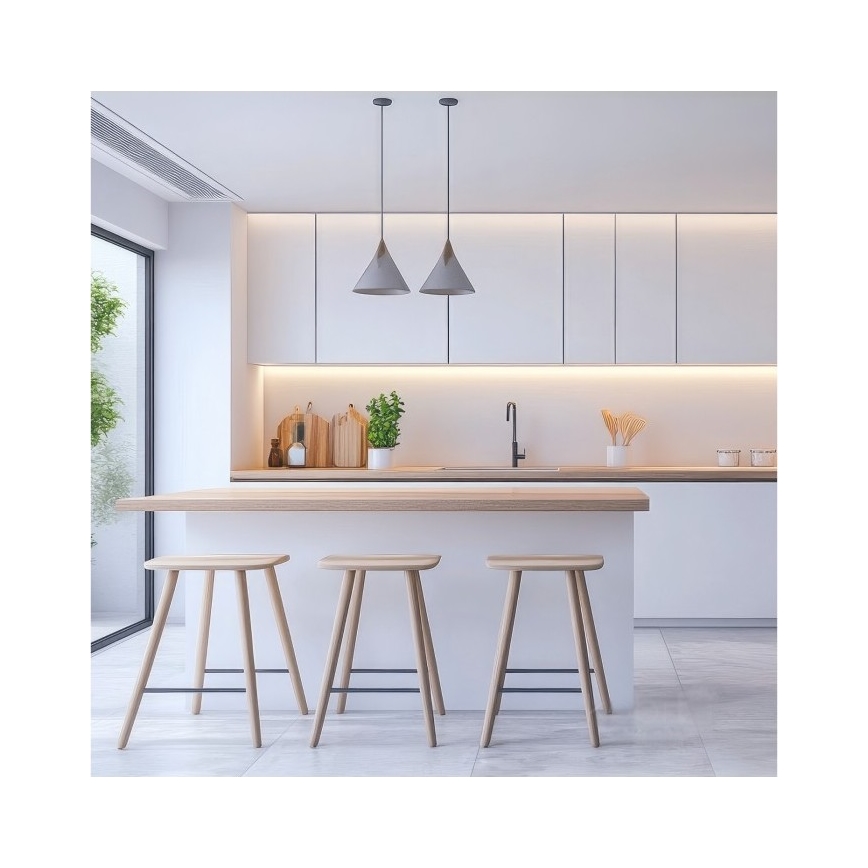 Drevené barové stoličky stoja pri kuchynskom ostrovčeku s drevenou doskou. Ostrovček je súčasťou modernej, svetlej kuchyne s bielymi skrinkami a dvoma visiacimi lampami.