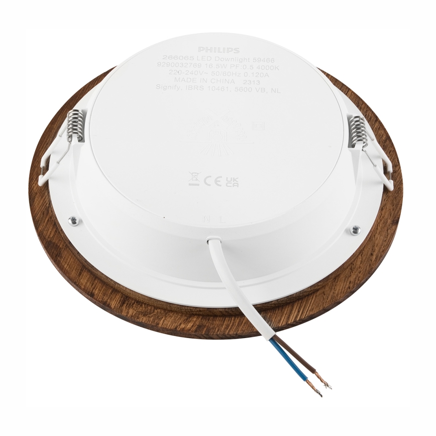Svietidlo s dreveným rámom je pripojené k elektrickému vedeniu. Zadná strana svietidla ukazuje technické údaje: 286065 LED Downlight 59-468, 9290032789 16 5W PF:0.5 4000K, 220-240V-50/60Hz 0.120A, MADE IN CHINA 2313, Signify IBRS 10461, 5600 VB, NL.