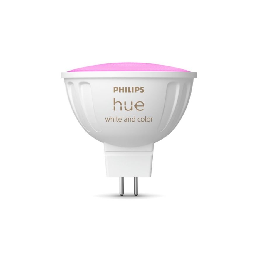 LED žiarovka Philips Hue svieti ružovo. Je biela s dvoma kovovými kolíkmi na spodku. Na nej je text: PHILIPS hue white and color.